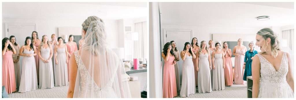 Bride reveals her dress to her bridesmaids. They all have a surprised, loving expression